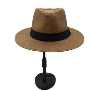 Close-up of woven straw fedora hat in brown with a wide black decorative ribbon band