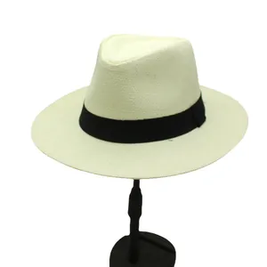 Detail of a breathable straw panama hat in cream with black ribbon and display stand