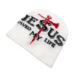 Detail of Jesus Saved My Life jacquard text and cross symbol on a white knit beanie