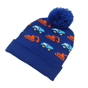 Dettaglio del berretto in maglia per bambini con scavatrici e grande pompon blu