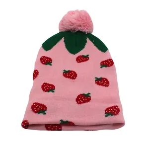 Roze gebreide muts voor meisjes met aardbeienpatronen en een zachte pompon bovenop
