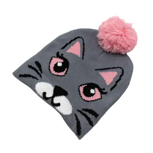 Détails de la maille d'un bonnet chat gris avec un pompon rose pour enfant