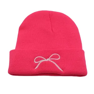 Pink knitted beanie with white bow embroidery and cuffed edge for winter outdoor warmth