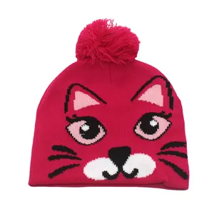 Détail du bonnet en tricot rose avec motif de chat et pompon décoratif moelleux