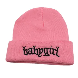 Detailansicht der Babygirl-Stickerei auf weicher rosa Strickmütze mit Umschlagrand