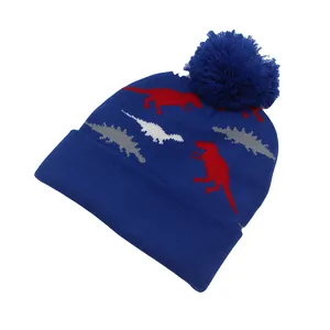 Gros plan du bonnet en tricot bleu marine avec jacquard de dinosaure et pompon doux