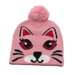 Détail du bonnet en maille rose avec pompon et motif de chat en jacquard mignon