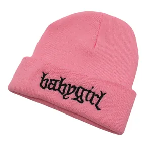 Nahaufnahme der Babygirl-Stickerei auf einer rosa Strickmütze mit feiner Rippstruktur
