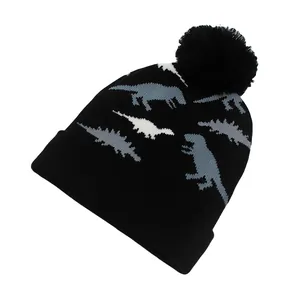 Détail du bonnet en tricot pour enfants avec motifs de dinosaures gris et pompon noir