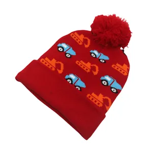 Dettaglio del cappello in maglia rossa per bambini con motivi di scavatrice e pompon