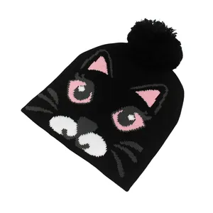 Détail du bonnet en maille chat noir avec pompon et broderie de dessin animé