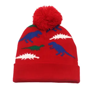 Détail du bonnet rouge en tricot avec jacquard de dinosaure et pompon doux pour enfants