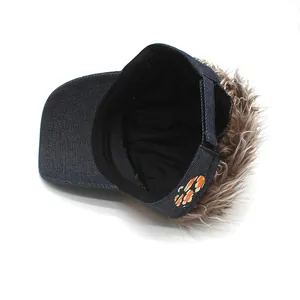 Detalle de gorra peluca de mezclilla azul con pelo rizado y cierre de camuflaje
