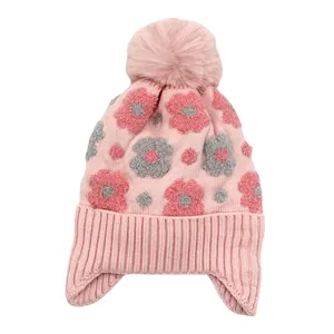 Détail du tricot de ce bonnet d'hiver rose pour fille avec fleurs et pompon doux