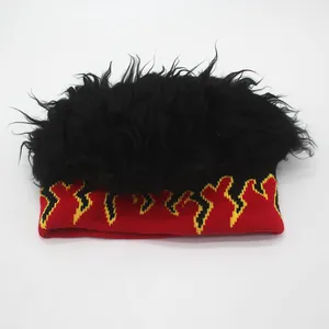 Detail of knitted beanie with yellow flame pattern and fluffy black faux hair top