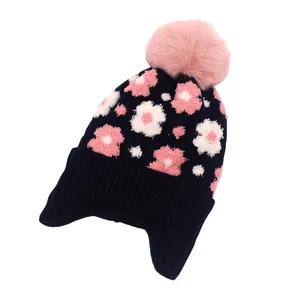 Détails de la texture tricotée du bonnet d'hiver pour fille avec motifs fleurs