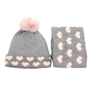Detail of grey knitted hat and scarf set with pink heart pattern and faux fur pom-pom