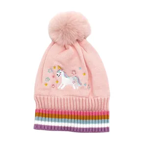 Détail de la broderie licorne et du bord rayé sur le bonnet d'hiver en tricot rose enfant