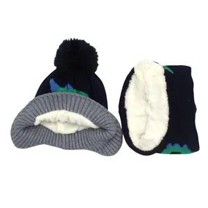 Detail of kids knit hat and scarf set with thick fleece lining and cartoon dinosaur pattern