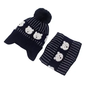 Detail of navy knit baby hat and neck warmer set with white bear motif and soft pom pom