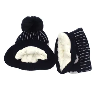 Detail of navy knit hat and scarf set with thick white fleece lining and soft pom-pom