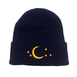 Navy blue knitted beanie with yellow moon and star embroidery on the fold-up cuff