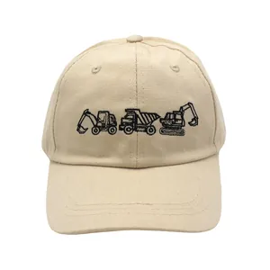 Detailed embroidery of black construction trucks on a beige cotton kids baseball hat