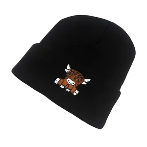 Close-up of black knit beanie featuring a colorful Highland cow embroidery detail