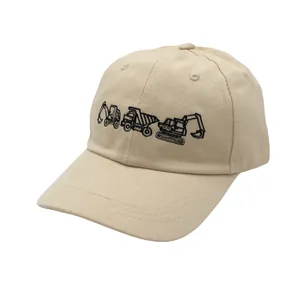 Detailed view of black construction vehicle embroidery on a beige cotton baseball cap