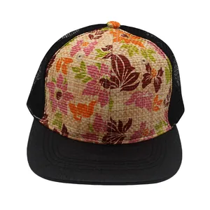 Detail of woven straw crown with floral print and black crocodile textured brim