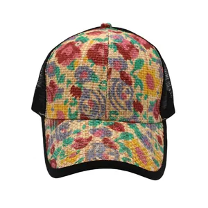 Detail der gewebten Stroh-Trucker-Cap mit lebhaftem Blumenmuster und schwarzem Netz