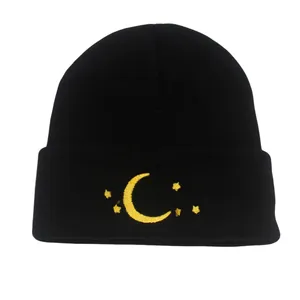 Black knit beanie with yellow moon and stars embroidery on a cuffed winter hat