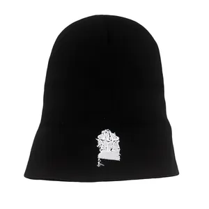 Dettaglio del ricamo grafico bianco su un berretto in maglia nera spessa invernale