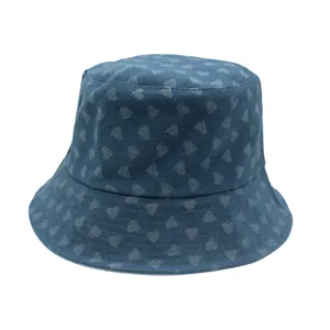 Detalle del sombrero de pescador en denim azul con pequeños corazones blancos y ala estrecha