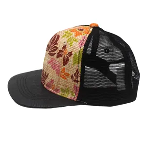 Detail of floral straw trucker hat featuring black mesh back and snakeskin texture brim