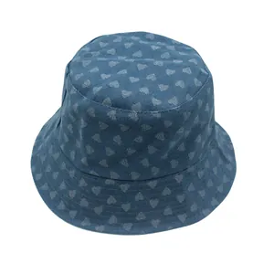 Detalle de sombrero de pescador en denim azul con patrón de corazones blancos y ala reforzada