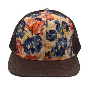 Detail of floral straw crown and brown crocodile-embossed brim on a mesh trucker hat