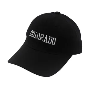 Detail of white COLORADO embroidery on a black cotton baseball cap for kids