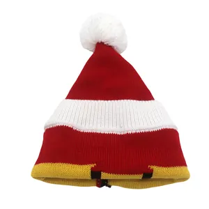 Texture de maille détaillée d'un bonnet de Noël rayé rouge et blanc avec pompon