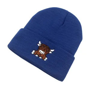 Close-up of navy blue knit beanie featuring detailed Scottish Highland cow embroidery