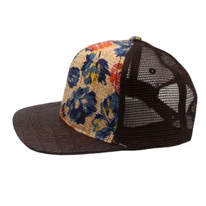Detail of floral printed straw baseball cap with brown crocodile texture brim