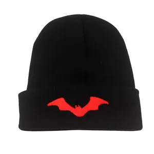 Dettaglio del ricamo a pipistrello rosso su un berretto in maglia a coste nero