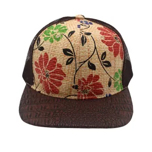 Detail of floral print straw crown and brown crocodile pattern brim mesh cap