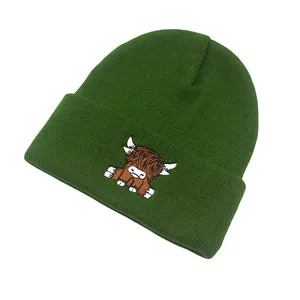 Detail of Highland Cow embroidery on a dark green knitted beanie for winter warmth