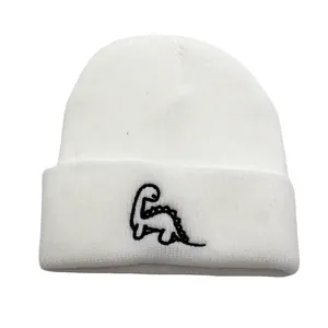 Détail de la broderie dinosaure noir sur le revers du bonnet blanc tricoté