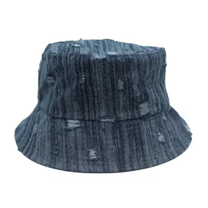 Detalle de sombrero de pescador en denim lavado con textura vintage y rotos decorativos
