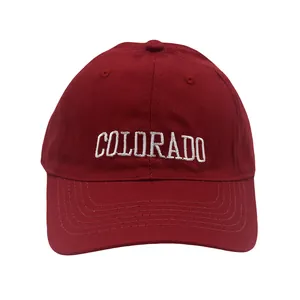 Close-up of white COLORADO embroidery on a burgundy cotton twill baseball cap