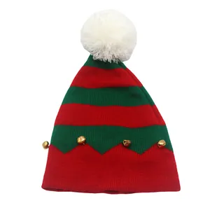 Détail du bonnet de Noël en tricot avec rayures rouges, bordure verte et grelots dorés