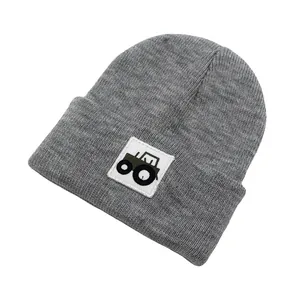 Dettaglio del cappello in maglia grigio scuro per bambini con toppa a forma di trattore