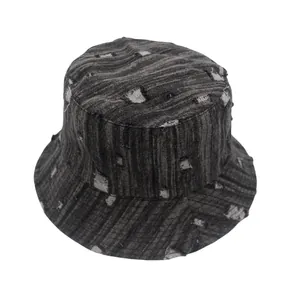 Detalle de gorro de pescador en denim gris lavado con acabados vintage desgastados y textura